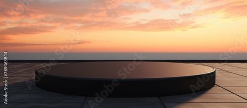 A black podium stands on a tiled floor against the backdrop of the ocean at sunset, with a red sky at dusk and the horizon blending with the natural landscape © pngking