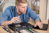 close-up of young man trying to fix his computer