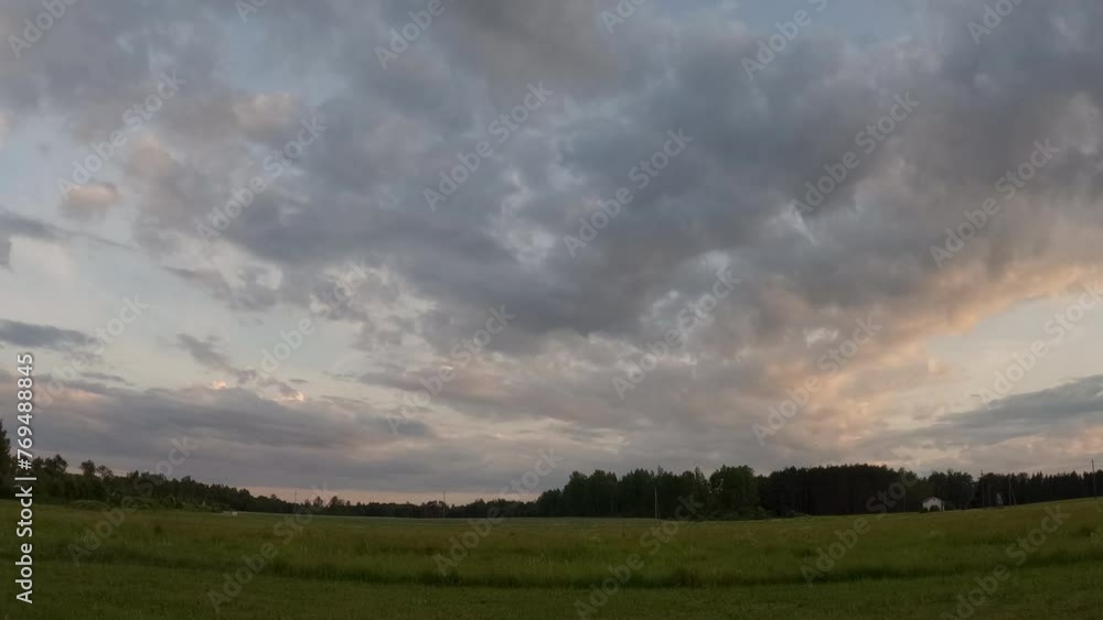 Serene evening sky with pastel clouds over quiet countryside field in Estonia Serene evening sky with pastel clouds over quiet countryside field in Estonia