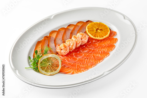 Sliced delicacy fish: salmon and butter fish and shrimp on a white plate. Banquet festive dishes. Gourmet restaurant menu. White background.