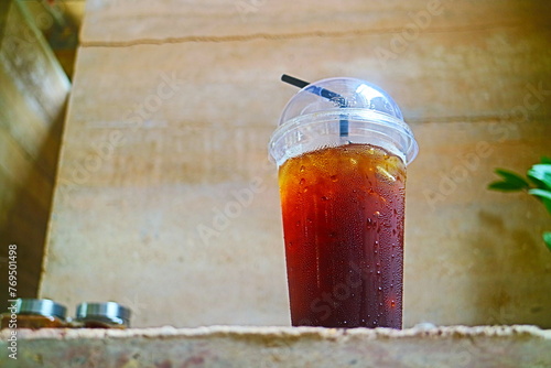Close up of  a cup of ice coffee on an earthen table photo