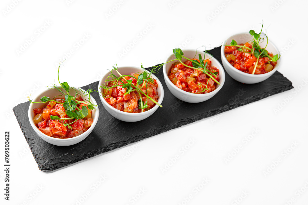 Salmon buffet appetizer, tartare on a white plate. Banquet festive dishes. Gourmet restaurant menu. White background. Salmon buffet appetizer, tartare on a white plate. Banquet festive dishes. Gourmet restaurant menu. White background.