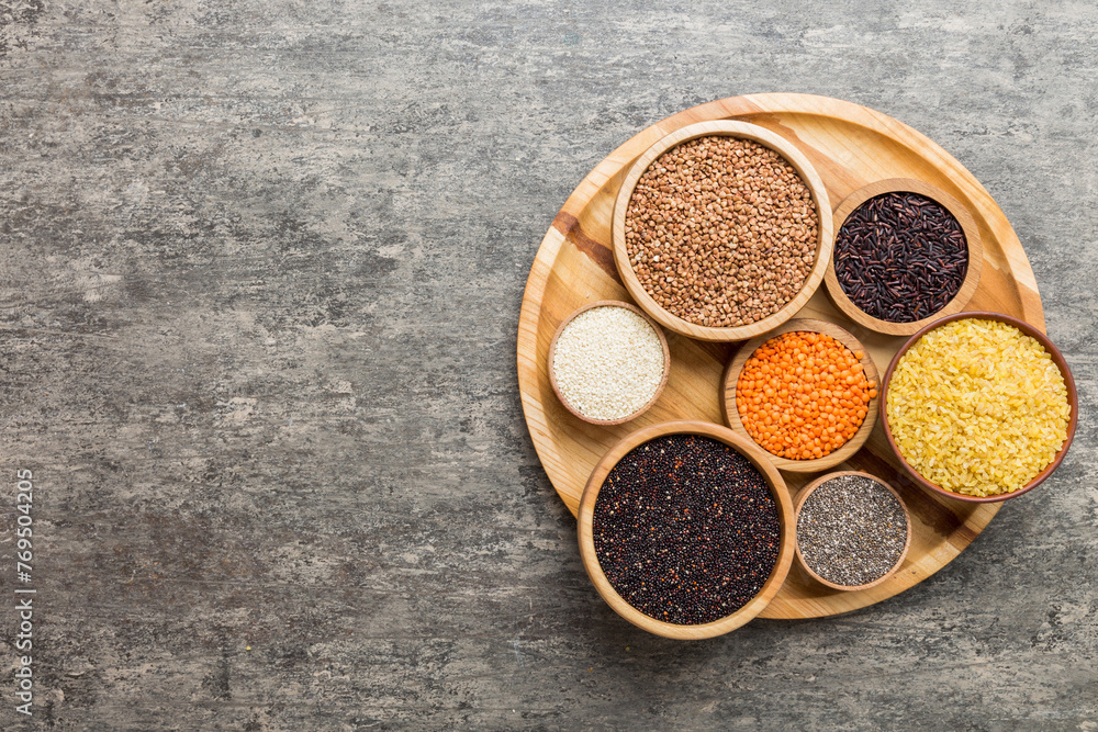 Various superfoods in smal bowl on colored background. Superfood as rice, chia, quinoa, lentils, nuts, sesame seeds, almonds. top view Various superfoods in smal bowl on colored background. Superfood as rice, chia, quinoa, lentils, nuts, sesame seeds, almonds. top view