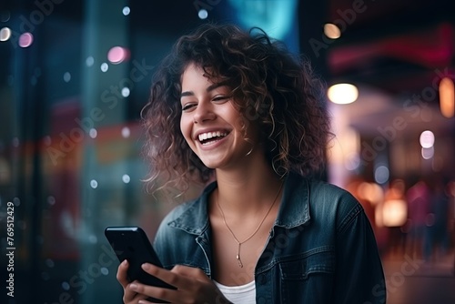 Smiling woman using smartphone at night © BetterPhoto