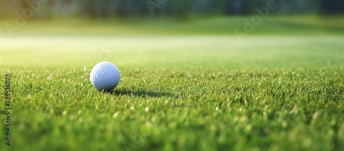 A Golf ball rests on the smooth green grass of a golf course, ready for the next shot in a competitive golf event
