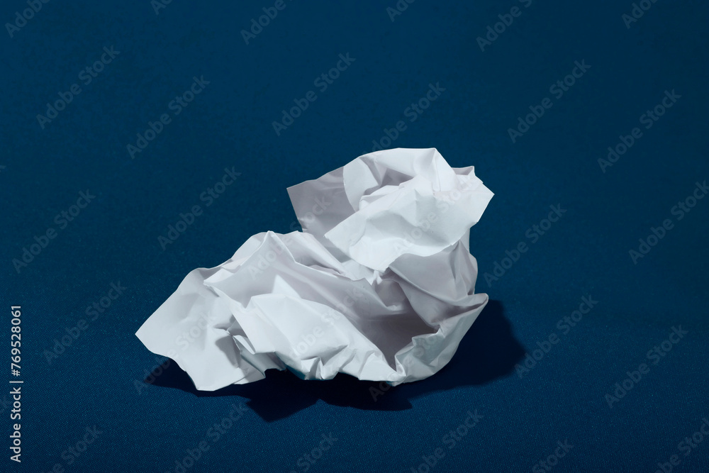 White crumpled paper over blue background White crumpled paper over blue background
