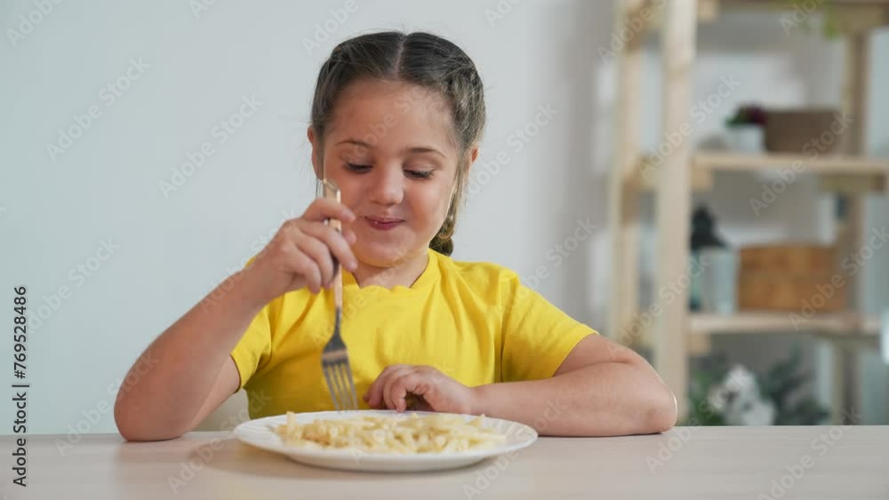 Happy family concept.child sits at the kitchen table and eats pasta with fork. delicious appetizing lunch. happy child eats freshly prepared pasta. healthy eating. lunch snack. delicious lunch at home Happy family concept.child sits at the kitchen table and eats pasta with fork. delicious appetizing lunch. happy child eats freshly prepared pasta. healthy eating. lunch snack. delicious lunch at home