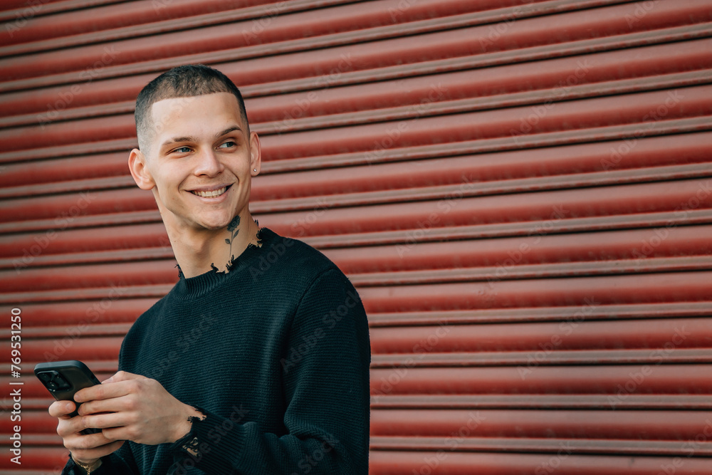 Obraz premium young man with mobile phone and bicycle on the street in red background