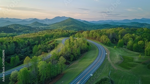 Bird's eye view curves the road in a beautiful green forest.