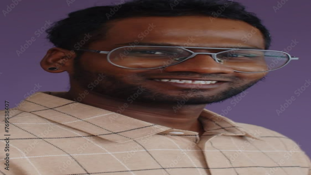 Vertical portrait of young man posing for camera against lilac background Vertical portrait of young man posing for camera against lilac background