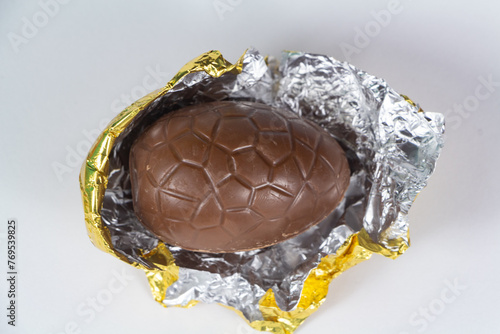 Chocolate egg for easter unwrapped from its golden paper