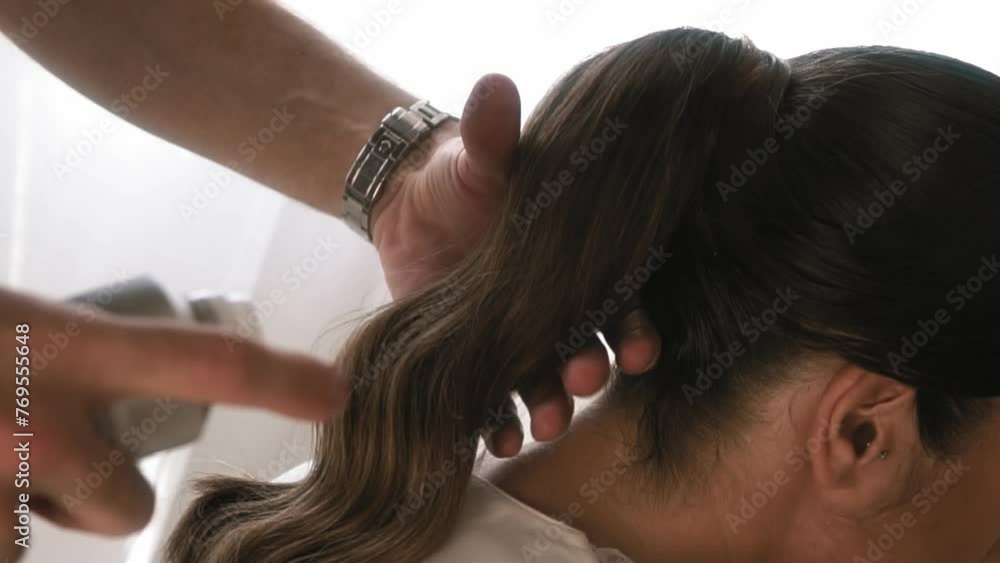 Woman getting her hair sprayed by male hairdresser for her wedding. Woman getting her hair sprayed by male hairdresser for her wedding.