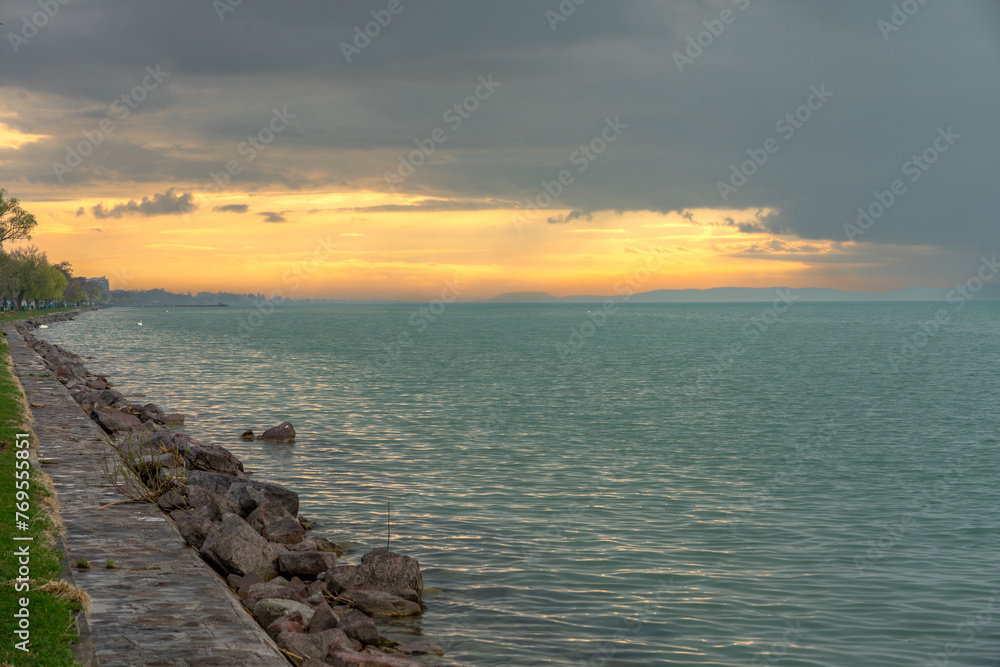 Balatonvilagos beach shore cloudy sunset next to Lake Balaton