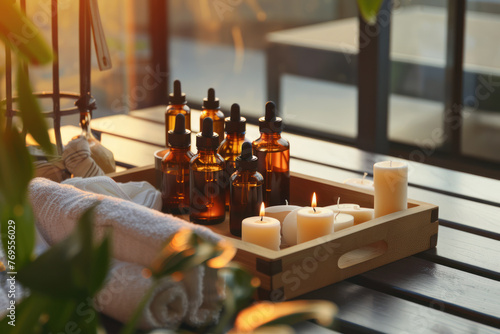 Cosmetic oil for massage and spa ritual with towels, candles and flowers in a wooden tray. Spa beauty room.