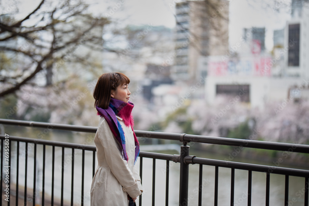 桜の咲く街を眺める女性 桜の咲く街を眺める女性