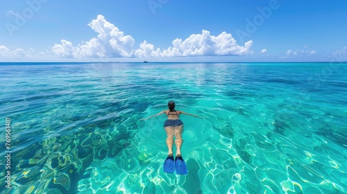 Joy and freedom of swimming in the clear,blue ocean The swimmer,equipped with snorkeling gear,is immersed in the marine world,surrounded by the serene beauty photo