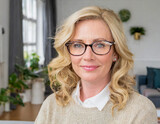 portrait of cherful forty year old blonde woman wearing glasses in her house