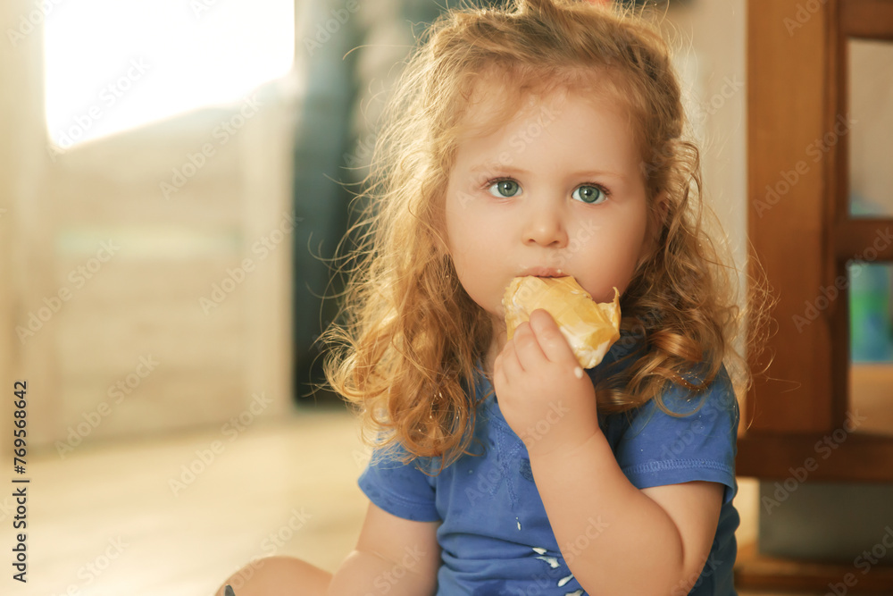 Lovely little girl sitting on the floor and eating ice cream. Summer mood, beautiful child with big green eyes and red hair. Happy childhood and motherhood Lovely little girl sitting on the floor and eating ice cream. Summer mood, beautiful child with big green eyes and red hair. Happy childhood and motherhood