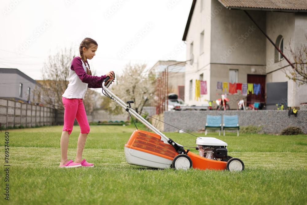 cute-teenage-child-girl-working-in-garden-mowing-green-grass-with-lawn