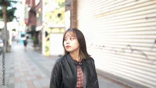 A young Japanese woman from Okinawa Prefecture in her 20s walking alone on Kokusai Street in Naha City, Okinawa Prefecture 沖縄県那覇市の国際通りを一人で歩く20代の沖縄県出身の若い日本人女性 photo