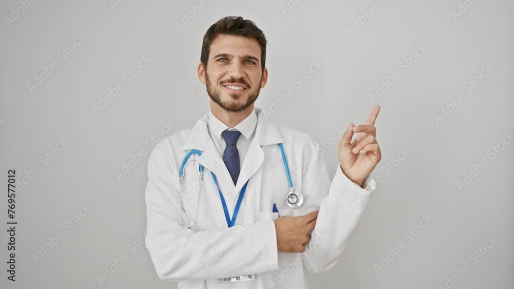 Young hispanic man wearing stethoscope with a big smile on face, pointing with hand finger to the side looking at the camera. over isolated white background Young hispanic man wearing stethoscope with a big smile on face, pointing with hand finger to the side looking at the camera. over isolated white background