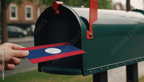 Close-up of person putting on letters with flag Laos in mailbox