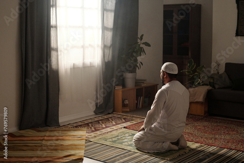 Mature Muslim Man Praying In Living Room photo