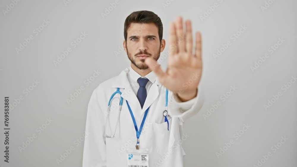 Handsome hispanic man, doctor-stethoscope-wearer, fiercely performs 'no-go' with resolute palm. warns, decidedly serious face, manifests stern refusal. isolated on pure white background. Handsome hispanic man, doctor-stethoscope-wearer, fiercely performs 'no-go' with resolute palm. warns, decidedly serious face, manifests stern refusal. isolated on pure white background.