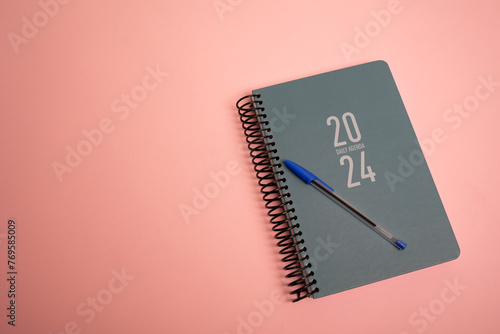 diary notebook and pen on the pink background © Andrei