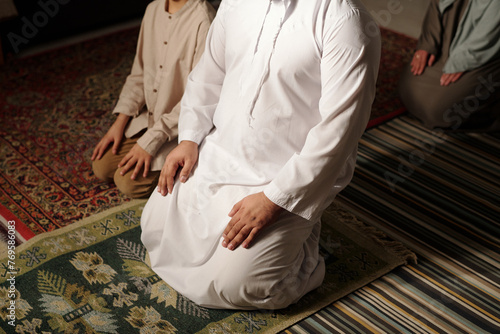 Unrecognizable Muslim Family Praying Salah photo