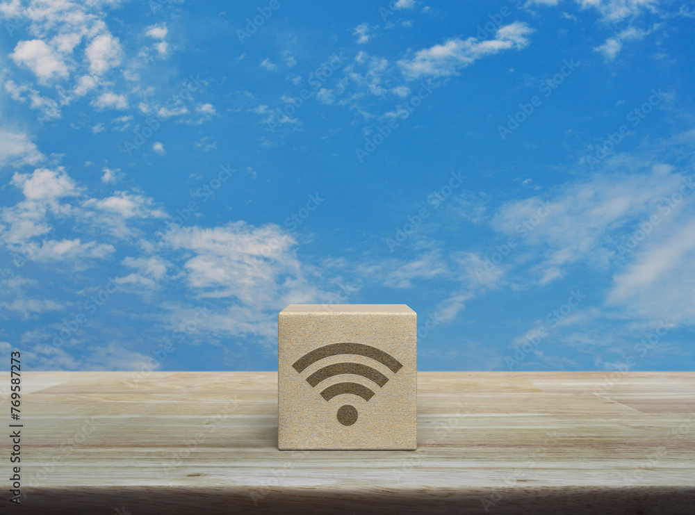 Wi-fi icon on wood block cube on wooden table over blue sky with white clouds, Technology internet communication concept - obrazy, fototapety, plakaty 