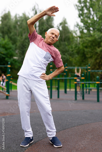 Portrait of senior man doing workout before training in park