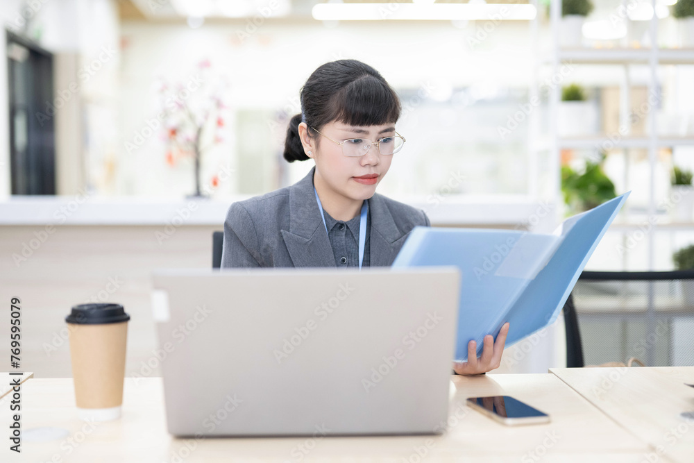 Fototapeta premium White-collar worker looking at documents carefully in office