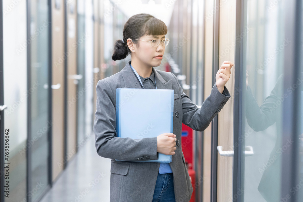White-collar worker holding a folder and knocking on the door White-collar worker holding a folder and knocking on the door