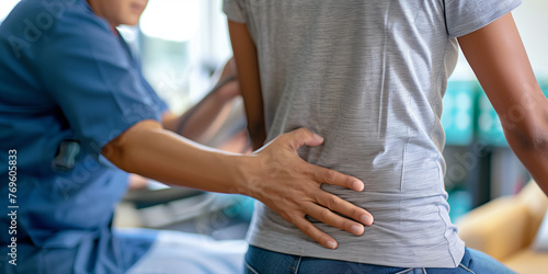 Physiotherapeut tastet den Rücken eines Patienten ab.