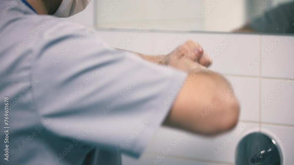 A medical worker washes his hands before surgery in a modern clinic. Concept of cleanliness, surgery and sterility. A medical worker washes his hands before surgery in a modern clinic. Concept of cleanliness, surgery and sterility.
