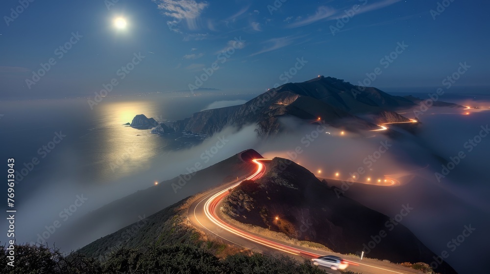 A foggy mountain road with a bright moon in the sky
