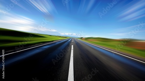 A blurry shot of a road with a blue sky in the background © jiawei