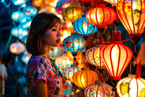 Festive lanterns illuminated in vibrant colors with blurred face of a woman enjoying the lantern festival photo