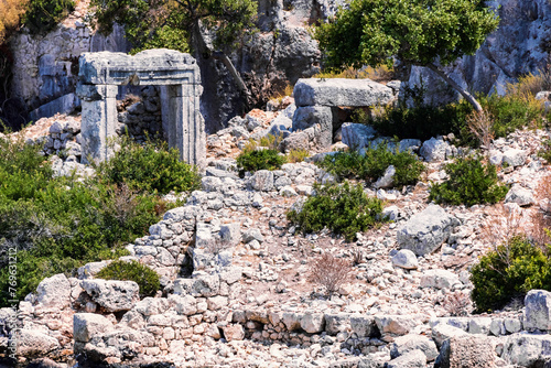 Time-worn Lycian ruins stand among wild shrubs on Kekova Island, vibrant colors. Famous boat tour from Demre, Antalya, Turkiye (Turkey)