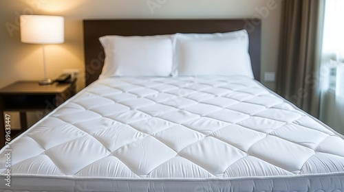 Close up of white mattress protector on well made bed for optimal protection and comfort