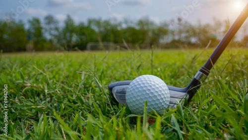 Golf ball and golf club in a beautiful golf course in Thailand. Collection of golf equipment resting on green grass with green background