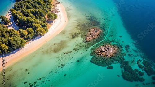 Aerial view of a secluded tropical beach  Island with rocky formations  palm trees and clear aquamarine waters.