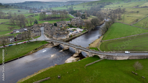 Aerial View of Burnsall bridge. One of the most beautiful villages in Wharfedale, Burnsall lies on a bend of the River Wharfe surrounded by a spectacular circle of fells.  photo