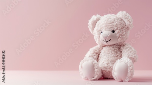 A soft pink bear sits against a pastel background, evoking sense of warmth and comfort.