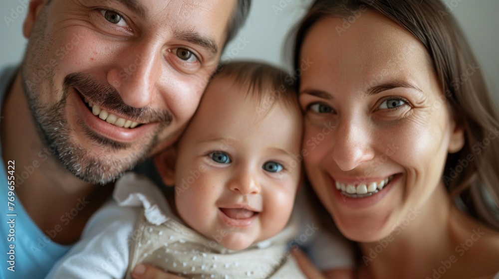 A joyful family portrait with a smiling man a woman and a baby with blue eyes all sharing a warm and loving moment. A joyful family portrait with a smiling man a woman and a baby with blue eyes all sharing a warm and loving moment.