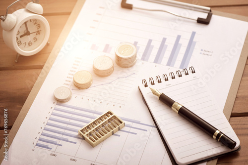Coins, abacuses, and pens placed on financial data reports