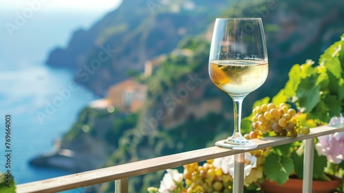 A glass of white wine on a balcony with scenic view coastal cliff and the sea.