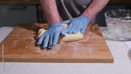 mani che lavorano l'impasto per la torta sul piano di legno photo