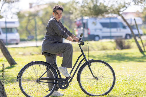 A woman is riding a bicycle in a park